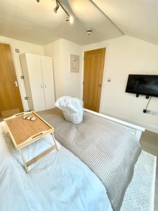 a living room with a table and a flat screen tv at Luxury en-suite double bedroom Stratford E15 in London