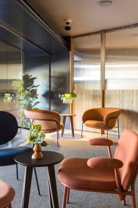 un groupe de chaises et de tables dans une salle d'attente dans l'établissement Hotel Terrassa Confort, à Terrassa