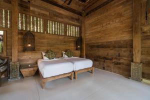 a bedroom with a bed in a wooden wall at Villa Sayang in Nusa Lembongan