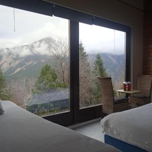 a bedroom with a view of a mountain through a window at Enoro in Pramanta