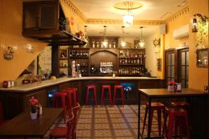 un bar con taburetes rojos en una habitación en Casa Rural La Botica en Jarandilla de la Vera