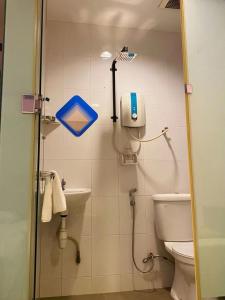 a bathroom with a toilet and a phone on the wall at Best Hotel in Skudai