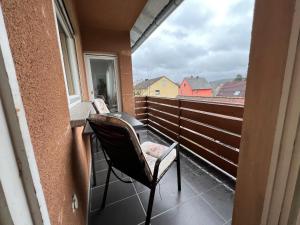 uma cadeira sentada numa varanda com vista para uma janela em Dill Apartment Pleinfeld I em Pleinfeld