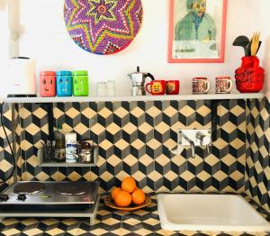 a kitchen with a black and white tiled wall at Dar 91 Essaouira in Essaouira
