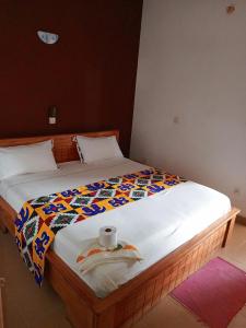 Una cama con una toalla y un rollo. en DG Hôtel en Cotonú