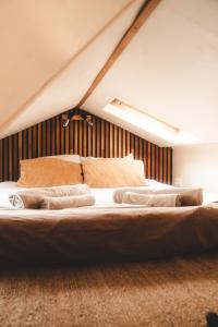 a bed with two pillows on it in a room at Tiny House Au Coeur de la Campagne Wallonne in Chaumont-Gistoux