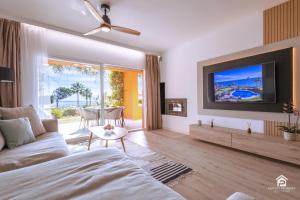 een woonkamer met een bank en een tv bij Apartment Los Molinos on the beachfront with pool in Estepona