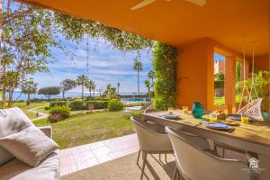 einen Tisch und Stühle auf einer Terrasse mit Meerblick in der Unterkunft Apartment Los Molinos on the beachfront with pool in Estepona