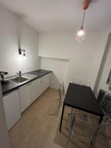 a kitchen with a black table and a sink at Relais Flora Arzo Appartamento superior di vacanza con posteggio in Mendrisio