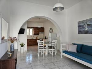 a living room and kitchen with a blue couch and a table at Sunny Home in Naxos Chora