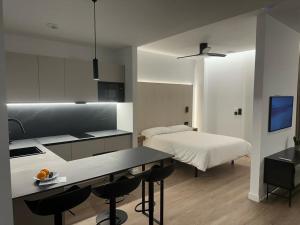 a kitchen and a bedroom with a bed and a table at Demetrio By Alma Suites in Valencia