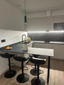 a kitchen with a table and two stools and a sink at Demetrio By Alma Suites in Valencia