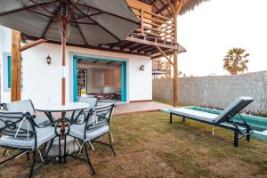 a patio with a table and chairs and an umbrella at Villa dos Poetas in Barra Grande