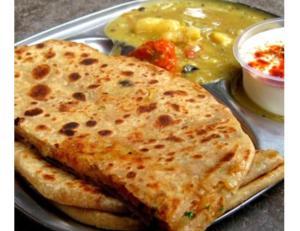 a plate of food with naan bread and a bowl of soup at Hotel Basant Inn, Srinagar in Srinagar