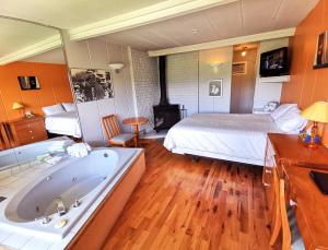 a bathroom with a bed and a bath tub and a bedroom at Motel Tremblant in Mont-Tremblant