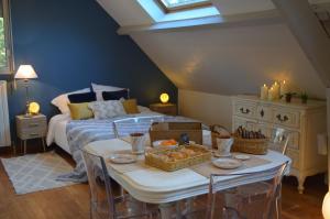 1 dormitorio con cama y mesa con cestas de comida en Le Copenhague, en Lamorlaye