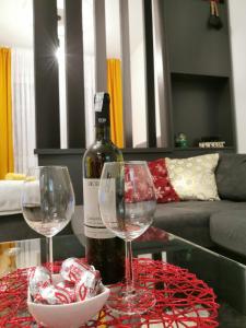 una bottiglia di vino e due bicchieri di vino su un tavolo di Apartman Vux a Banja Luka