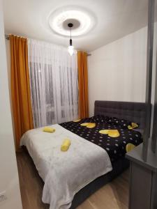 a bedroom with a bed with yellow pillows on it at Apartman Vux in Banja Luka
