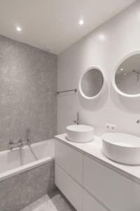 uma casa de banho branca com 2 lavatórios e uma banheira em Classy flat with awesome view and great location! em Antuérpia