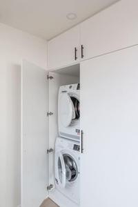 uma lavandaria branca com duas máquinas de lavar e secar roupa em Classy flat with awesome view and great location! em Antuérpia
