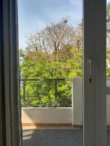 an open door to a balcony with a view of trees at QV Home in Ho Chi Minh City