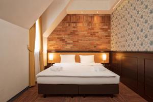 ein Schlafzimmer mit einem Bett und einer Ziegelwand in der Unterkunft Palazzo Rosso Old Town in Posen