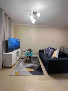Il comprend un salon doté d'un canapé et d'une télévision à écran plat. dans l'établissement Casa nueva, condominio cerrado, à Angol