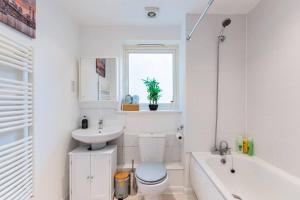 a bathroom with a toilet and a sink and a tub at Live the Wembley Buzz! Stylish Flat near Station & Amenities in London