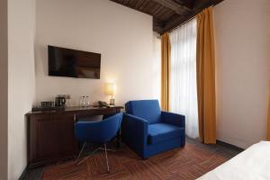um quarto de hotel com duas cadeiras azuis e uma secretária em Palazzo Rosso Old Town em Poznań