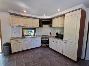 a kitchen with white cabinets and a stove top oven at Chalet Rust-ique in Putten