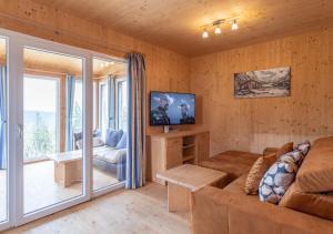 a living room with a couch and a tv at 1A Chalet Rast - Grillen mit Traumblick, Indoor Sauna in Bad Sankt Leonhard im Lavanttal