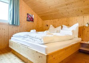 a bedroom with a large bed in a wooden room at 1A Chalet Rast - Grillen mit Traumblick, Indoor Sauna in Bad Sankt Leonhard im Lavanttal