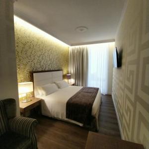 una camera d'albergo con letto e sedia di Hotel Montreal a Firenze