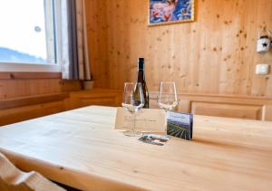 a bottle of wine and two glasses on a table at 1A Chalet Rast - Grillen mit Traumblick, Indoor Sauna in Bad Sankt Leonhard im Lavanttal