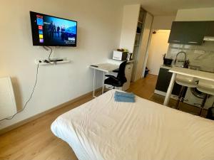 a hospital room with a bed and a tv on the wall at Exclusive Private Apartment by Warilco - Pleyel 25 m2 - À 1 minute de la station métro Carrefour Pleyel in Saint-Denis +2 photos
