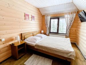ein Schlafzimmer mit einem Bett in einer Holzhütte in der Unterkunft Provence in Slawske