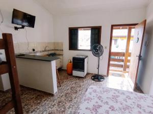 a kitchen with a sink and a fan in a room at Diva Surf Quartos in Ubatuba