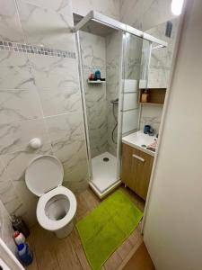 a small bathroom with a toilet and a shower at Exclusive Private Apartment by Warilco - Pleyel 25 m2 - À 1 minute de la station métro Carrefour Pleyel in Saint-Denis