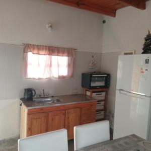 a kitchen with a sink and a refrigerator at Casa de Campo Atenea in Santiago del Estero