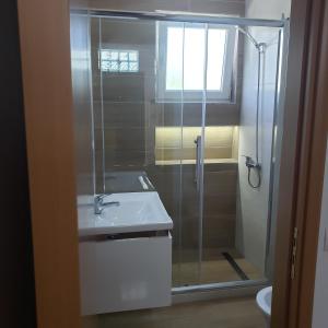 a bathroom with a glass shower and a sink at Pomegranates & Olives Guesthouse in Durrës