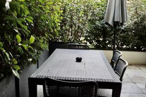 un tavolo con due sedie e un ombrellone su un patio di Apartment in Ferney close to Geneva United Nations a Ferney-Voltaire
