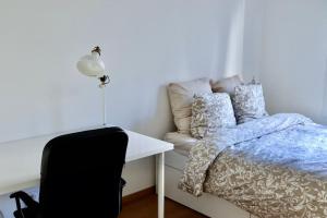 a bedroom with a bed and a table and a chair at Apartment in Ferney close to Geneva United Nations in Ferney-Voltaire