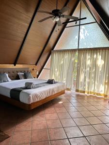 - une chambre avec un lit et un ventilateur de plafond dans l'établissement Luxurious 3BHK W//Pool Teakwood Villa By Gemstone Hospitality, à Alībāg