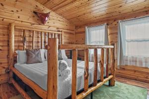 una camera con un letto in una baita di tronchi di Rock Face Lodge a Custer