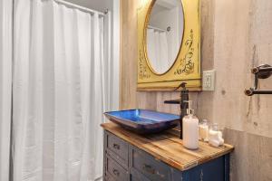 un bagno con un lavandino blu e uno specchio di Rock Face Lodge a Custer Altre 22 foto
