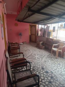 una stanza con sedie e una stanza con pareti rosa di RJM Home Stay a Tiruvannāmalai