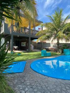 un complejo con piscina y palmeras en Casa de Praia LOFT 1 en Saquarema