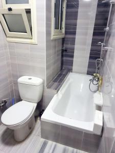 a bathroom with a toilet and a tub and a sink at Sea and Montaza Palace view 2 bedrooms apartment alexandria,2 full bathrooms, with 2 AC and 1 Stand Fan, wifi, 4 blankets available in Alexandria