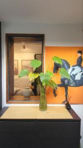 un vase avec des plantes sur une commode devant un miroir dans l'établissement 서촌 누하스테이-Nouhastay, à Séoul