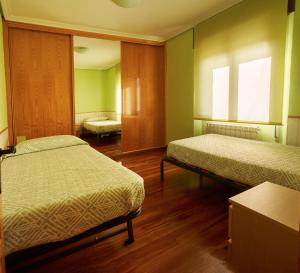 a hospital room with two beds and two windows at Chalet en Las Merindades, Nofuentes in Nofuentes